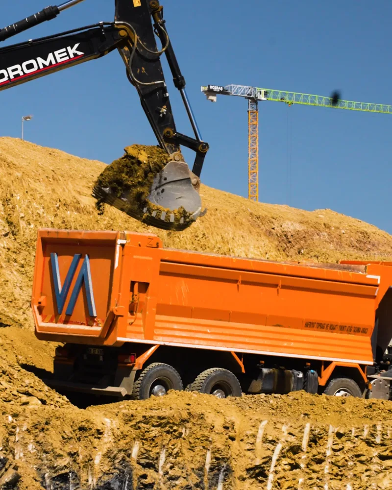 Loading an orange Dodurga dump truck.